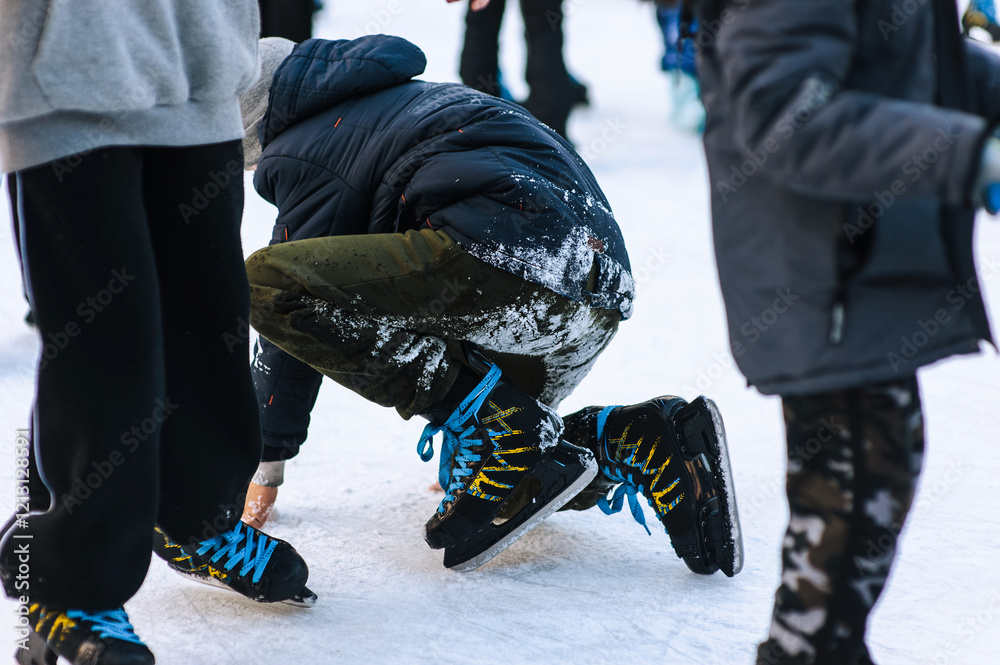 Happy adult stylish people skating, falling and slipping on rink in winter outdoors. Photography, legs close-up, sport and hobby concept. Happy adult stylish people skating, falling and slipping on rink in winter outdoors. Photography, legs close-up, sport and hobby concept.