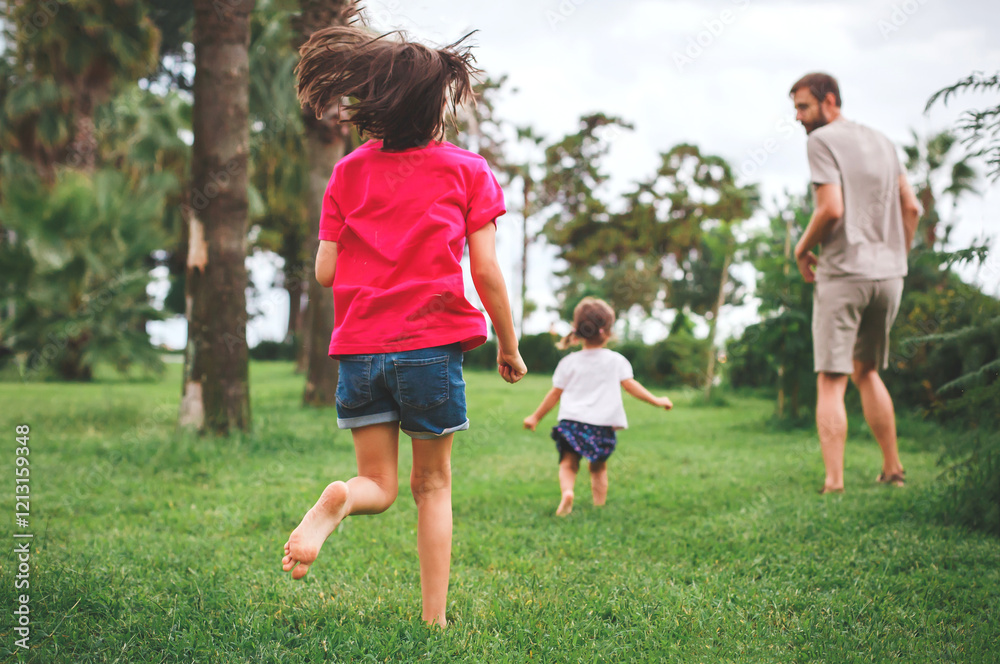 Father and two daughters running barefoot in a green park during summer, enjoying a playful and carefree moment together, concept of family and nature Father and two daughters running barefoot in a green park during summer, enjoying a playful and carefree moment together, concept of family and nature