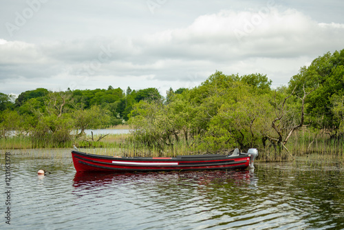 Boat for rent tied to small pier on Lough Leane, the largest and northernmost of the lakes of Killarney National Park, County Kerry, Ireland photo