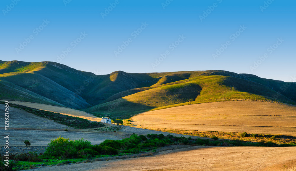 Panorama shot of a farmhouse in the rolling hills of Overberg during sunset, Caledon, South Africa