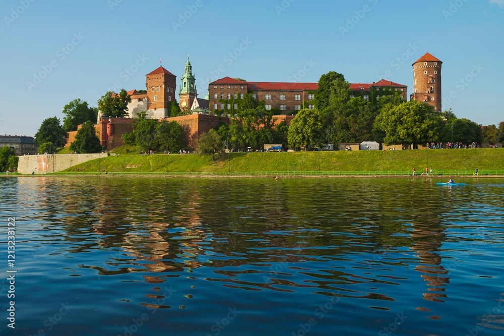 Obraz premium Historic Wawel Castle reflected in the Vistula River during a sunny day in Krakow