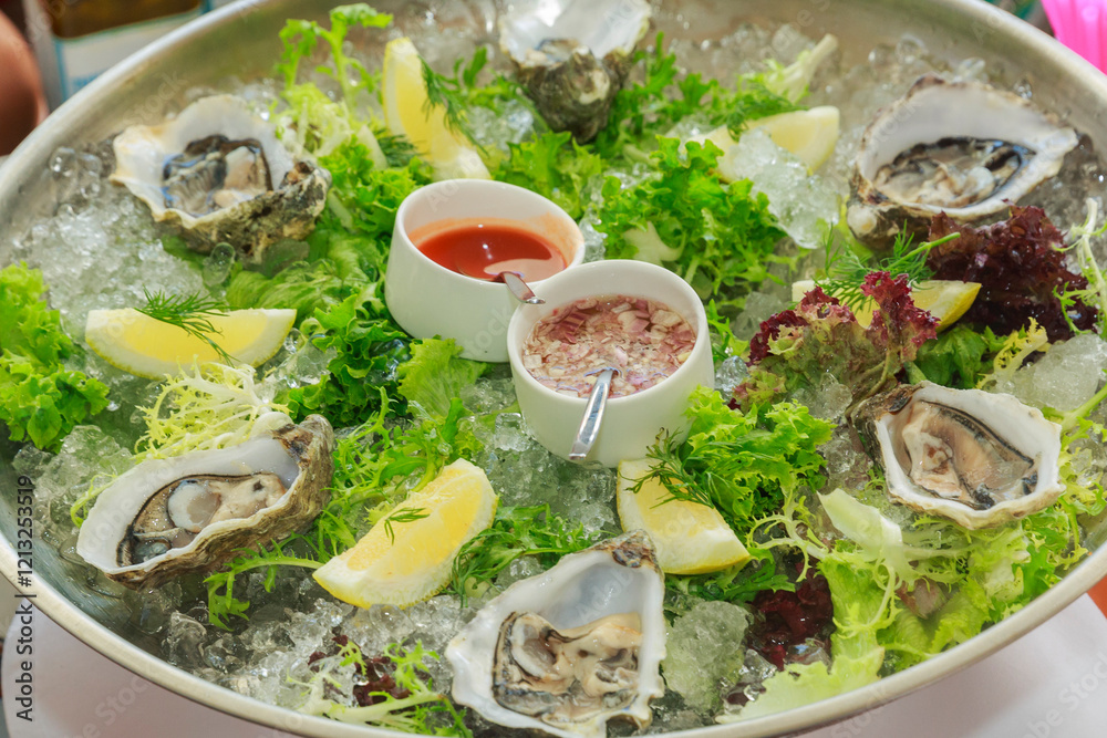 Close-up of a dish of fresh oysters with lemon and sauces Close-up of a dish of fresh oysters with lemon and sauces
