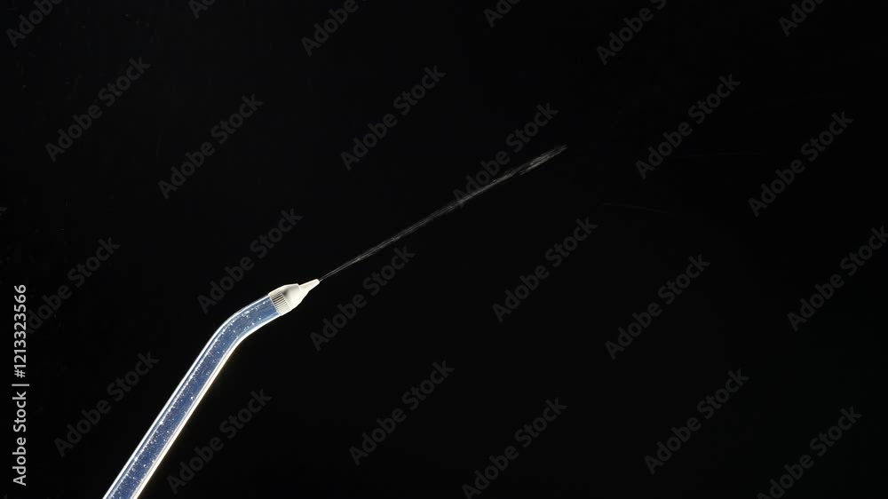 Portable oral irrigator on black background, close up. Dental teeth whitening, flosser bucal tooth cleaner, waterpulse, water thread for teeth. Stream of water from an irrigator nozzle Portable oral irrigator on black background, close up. Dental teeth whitening, flosser bucal tooth cleaner, waterpulse, water thread for teeth. Stream of water from an irrigator nozzle
