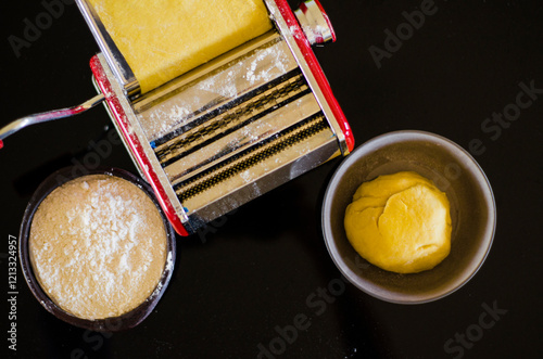 The fresh pasta and machine on kitchen table home made