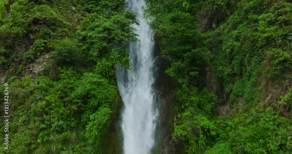 Drone Gliding Along Waterfall Amid Stunning Mountain Greenery Drone Gliding Along Waterfall Amid Stunning Mountain Greenery