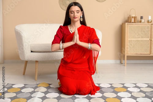 Young woman in red sari med...