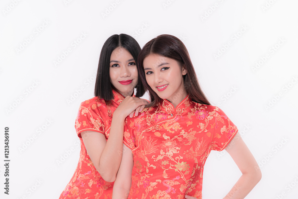 Two women in traditional red dresses pose stylishly against a white background. Two women in traditional red dresses pose stylishly against a white background.