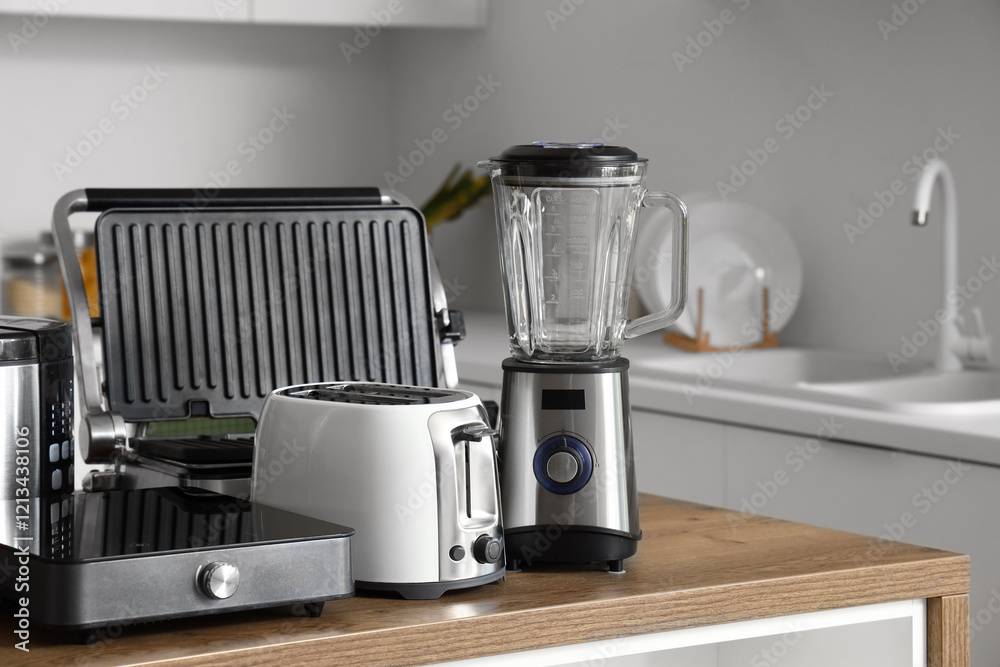 Set of modern appliances on wooden table in contemporary kitchen Set of modern appliances on wooden table in contemporary kitchen