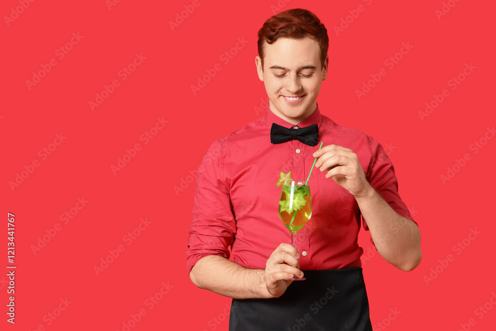 Young male bartender with glass of cocktail on red background Young male bartender with glass of cocktail on red background