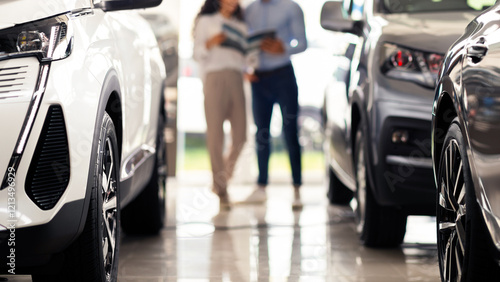 Wallpaper Mural Wealthy middle eastern young woman choosing new car, having conversation with friendly sales manager at brand new vip showroom, dealer showing retail brochure, blurred background Torontodigital.ca