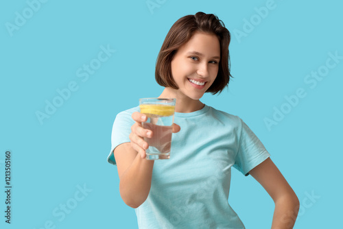 Pretty young woman with glass of infused water on blue background photo