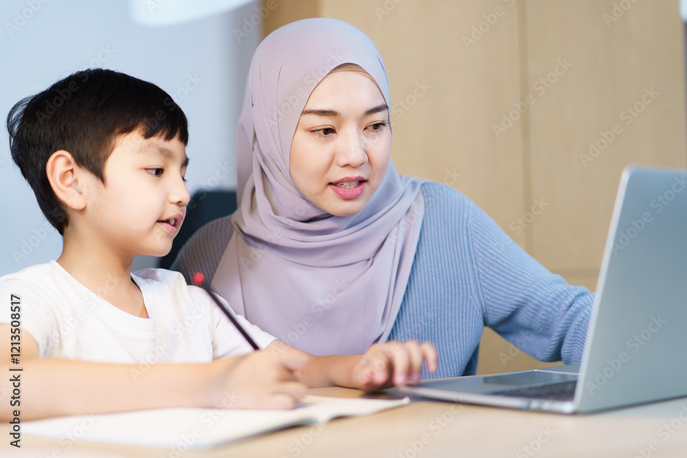 Asian muslim woman is teaching and reviewing homework with her son. Asian muslim woman is teaching and reviewing homework with her son.