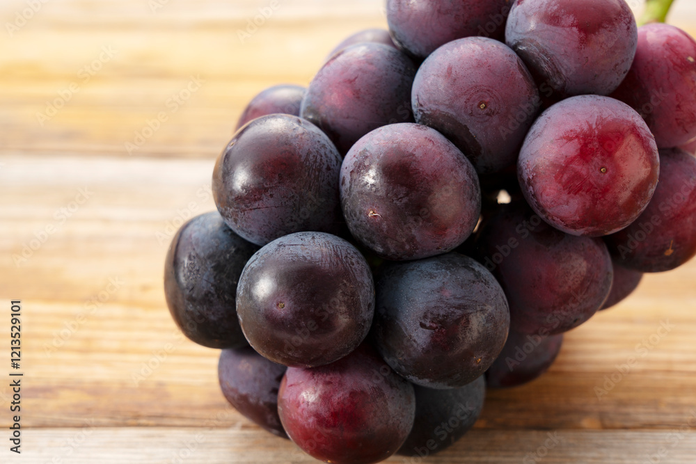 Fresh Japanese Pione Grapes Placed on a Wooden Surface Fresh Japanese Pione Grapes Placed on a Wooden Surface