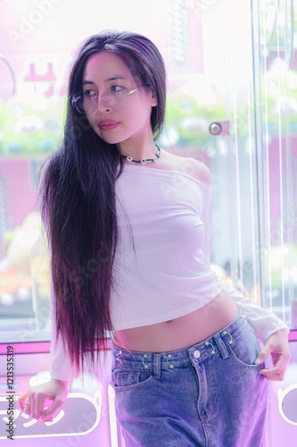 Young Woman in Casual Outfit Posing Near Neon Lights Background