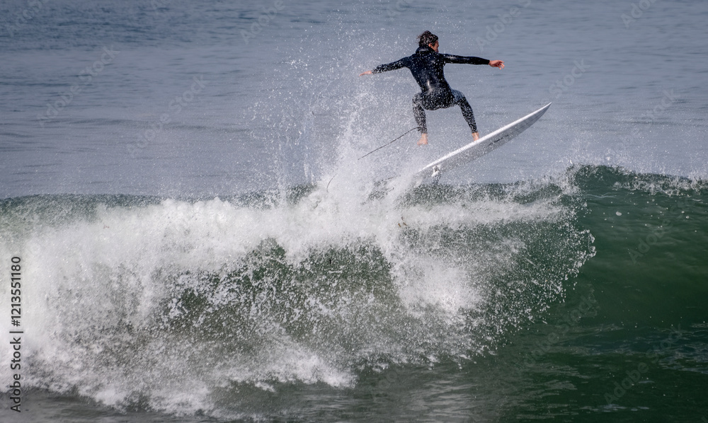 Surfer in wetsuit and surfboard riding large wave Surfer in wetsuit and surfboard riding large wave