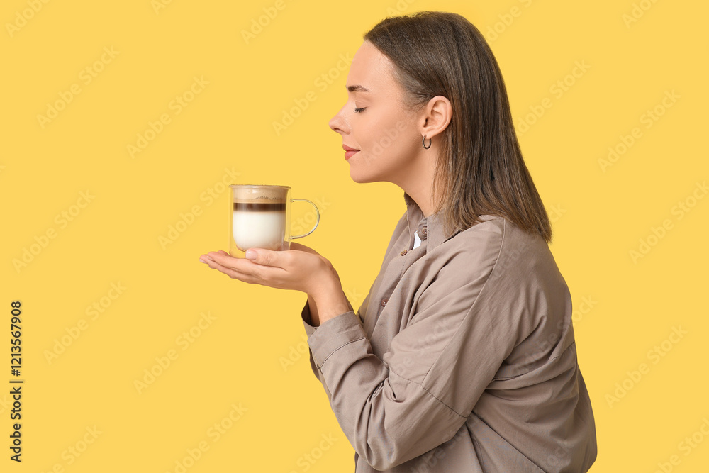 Beautiful young woman with glass cup of hot coffee on yellow background Beautiful young woman with glass cup of hot coffee on yellow background