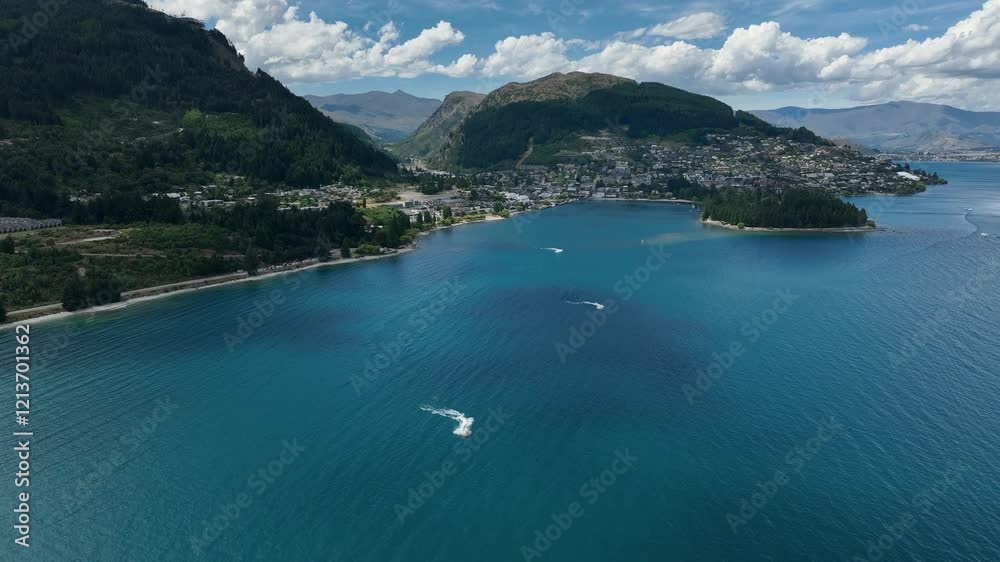 Flying toward Queenstown CBD with water sports in foreground