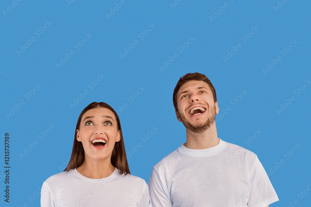 Wow. Closeup headshot of thrilled couple looking up at copy space isolated on pastel purple studio wall Wow. Closeup headshot of thrilled couple looking up at copy space isolated on pastel purple studio wall