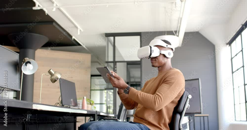 Using VR headset, African American man interacting with tablet in modern office workspace Using VR headset, African American man interacting with tablet in modern office workspace