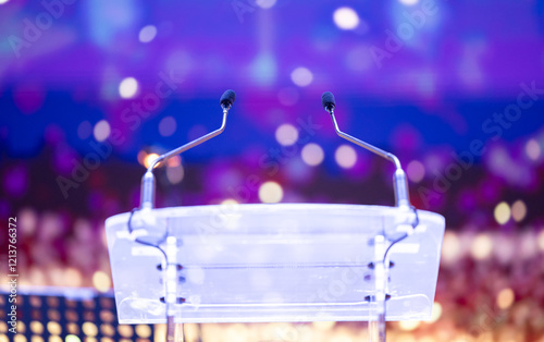Obraz na płótnie Two microphones on a clear podium with colorful bokeh lights in the background. Perfect for events and public speaking themes. Speaker desk. w salonie