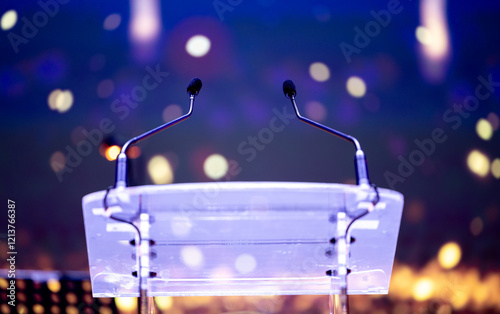 Obraz na płótnie Two microphones on a clear podium with colorful bokeh lights in the background. Perfect for events and public speaking themes. Speaker desk. w salonie