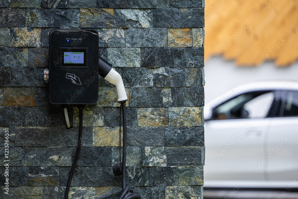 Wall-mounted electric car charging station outside a modern house, representing sustainable transportation. Electrical cars industry.