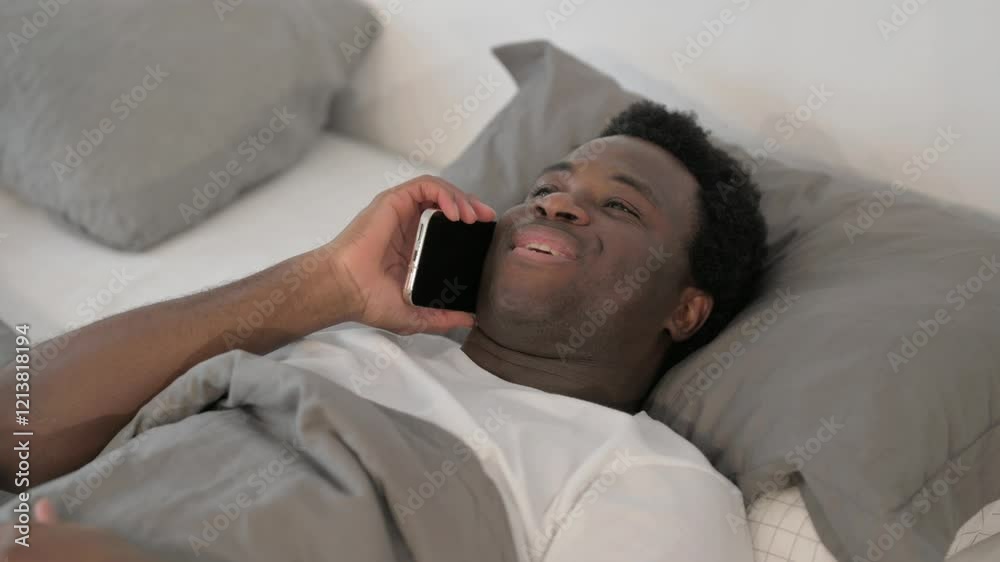 African Man Talking on phone while Lying in Bed African Man Talking on phone while Lying in Bed
