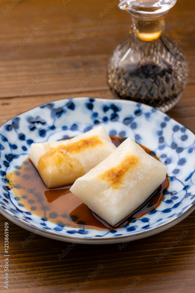 青い和柄の皿に盛られた焼き餅と砂糖醤油 青い和柄の皿に盛られた焼き餅と砂糖醤油