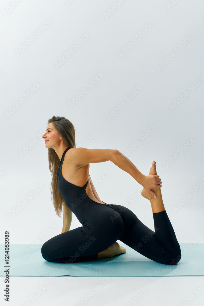 Fototapeta premium Studio, a sporty woman demonstrates her yoga practice, highlighting her dedication to fitness