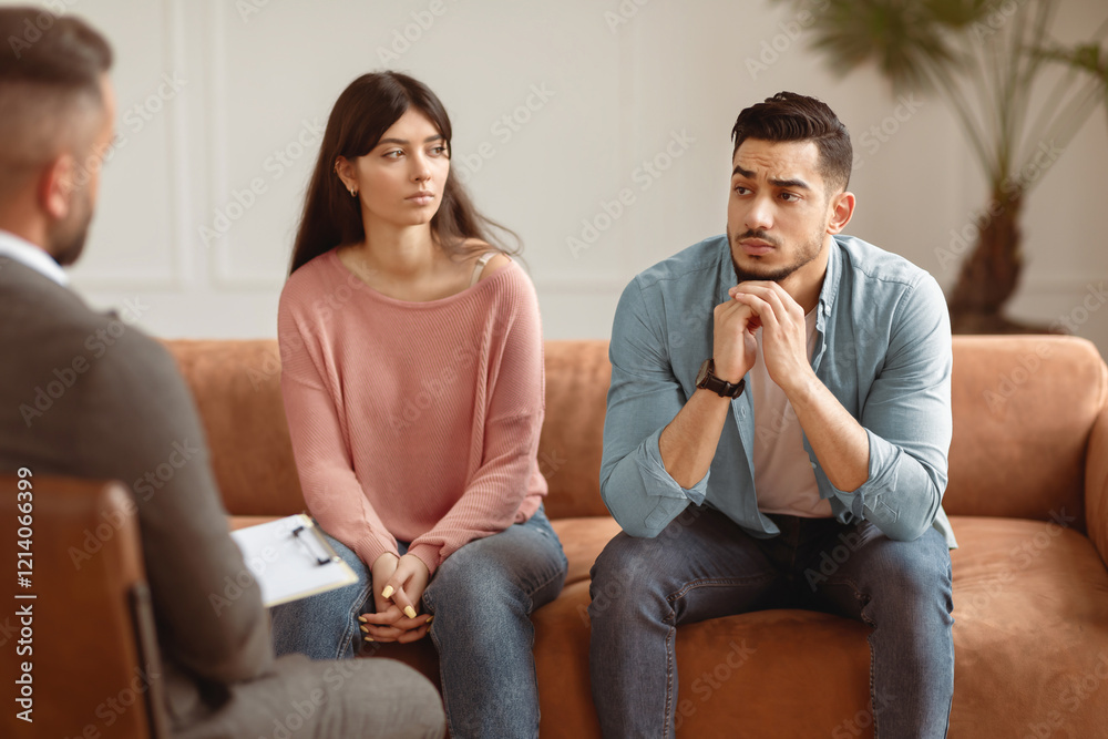 Family Psychologist Concept. Portrait Of Upset Sad Middle Eastern Couple Sitting On Couch Sofa In Office, Discussing Relationship Problems Thinking About Breakup Or Divorce. Mental Health Family Psychologist Concept. Portrait Of Upset Sad Middle Eastern Couple Sitting On Couch Sofa In Office, Discussing Relationship Problems Thinking About Breakup Or Divorce. Mental Health