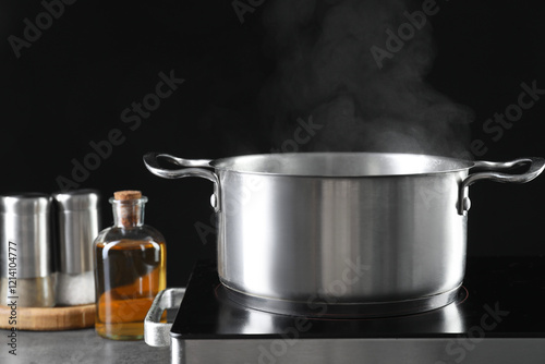 Metal pot on stove against black background