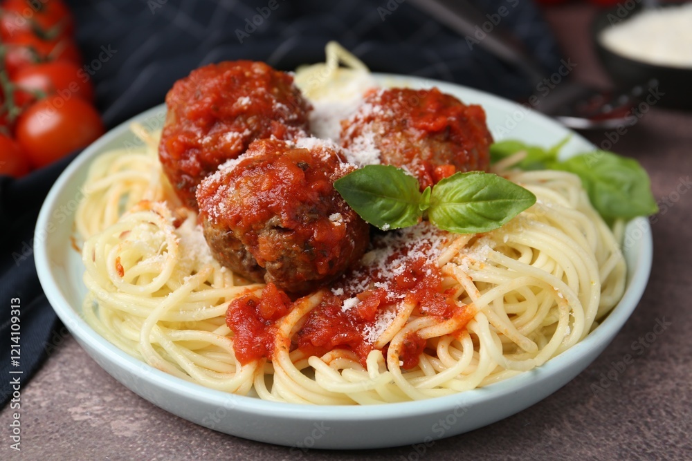 Delicious pasta with meatballs, basil and cheese on brown textured table, closeup Delicious pasta with meatballs, basil and cheese on brown textured table, closeup