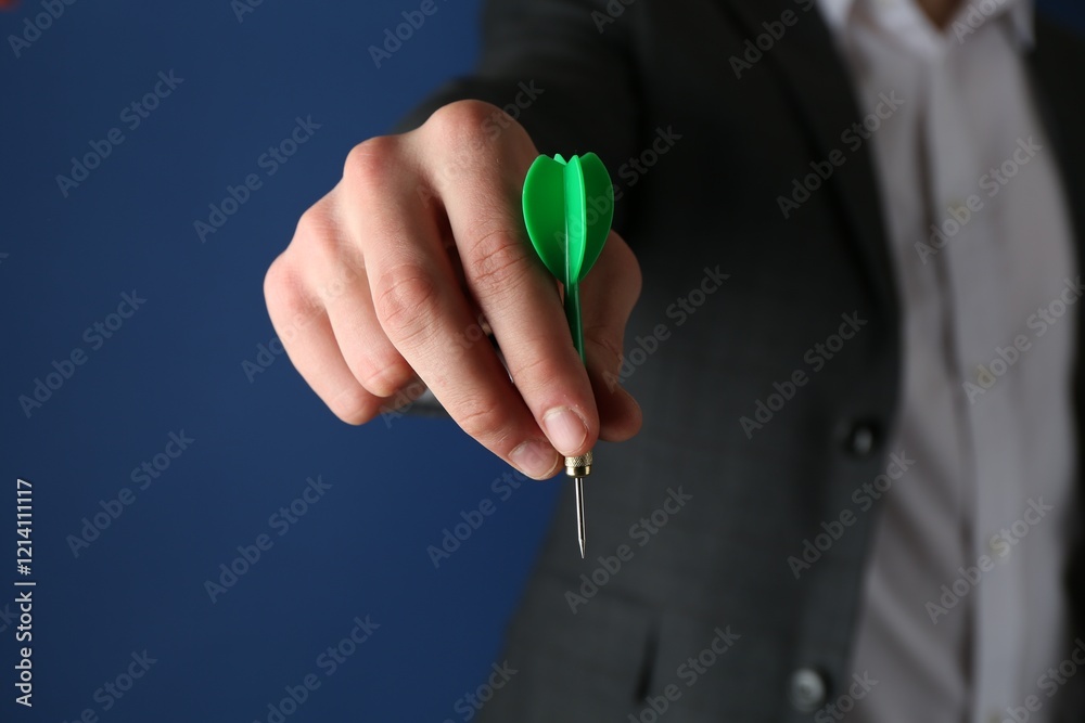 Fototapeta premium Man holding dart on blue background, closeup