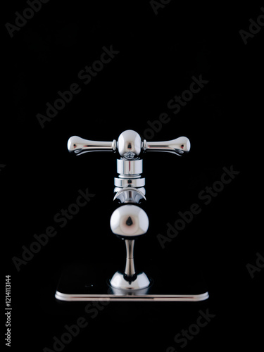 A photo of a chrome faucet against a black background photo