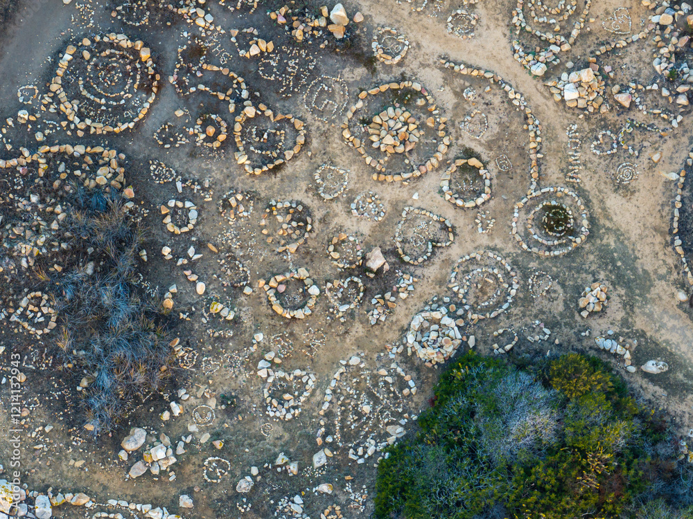 Aerial view of human made stone circle patterns of land art in coastal area in Sardinia. Aerial view of human made stone circle patterns of land art in coastal area in Sardinia.