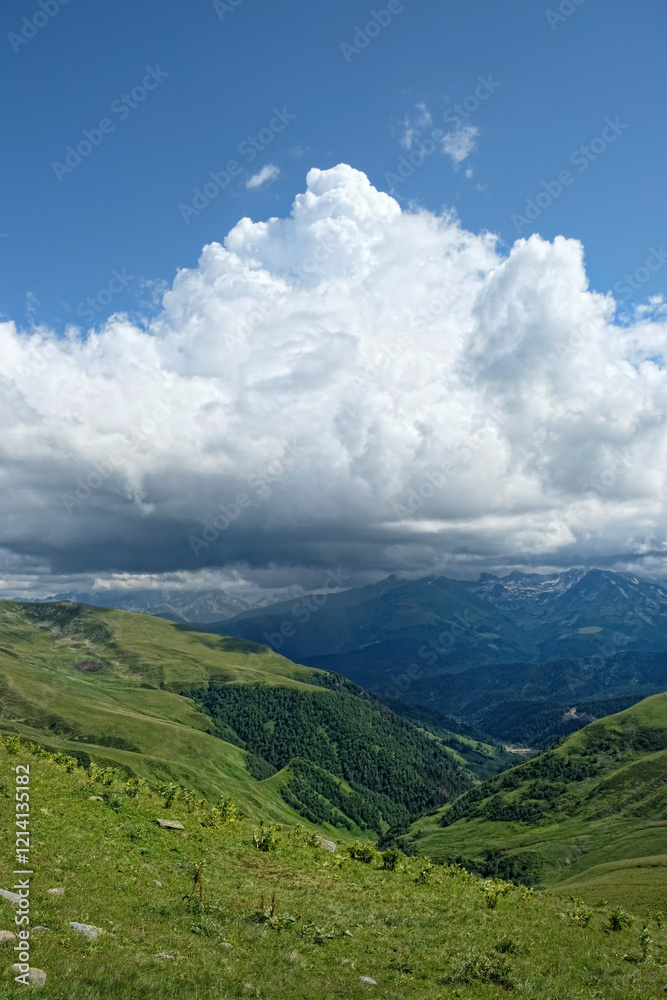 Obraz premium summer landscape with green mountains against blue cloudy sky, nature background. freedom, adventure, unity with wild nature, tourism, travel concept. scenic nature view. Arkhyz, Caucasus mountains