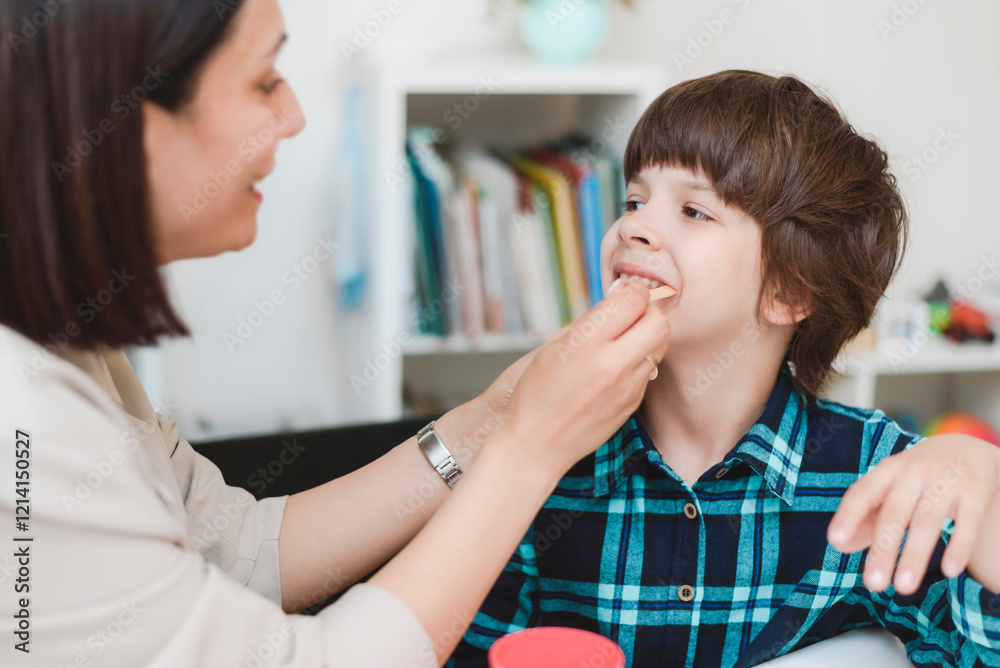Woman speech therapist helps a boy correct the violation of his speech Woman speech therapist helps a boy correct the violation of his speech