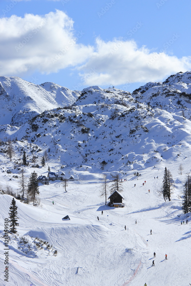 People having ski time in ski resort on a cold winter sunny day.
