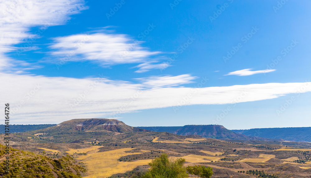 Fototapeta premium Landscape of eroded limestone hills. Yellow grass and scrub are distributed throughout the area