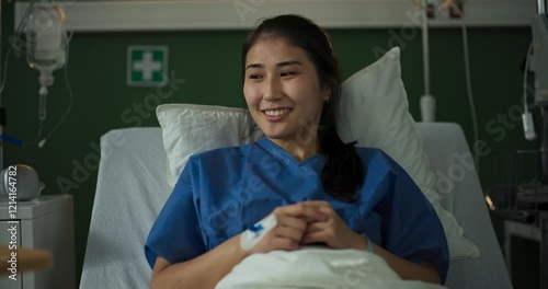 Young patient rests in her hospital bed as an African doctor brings her breakfast on a tray.