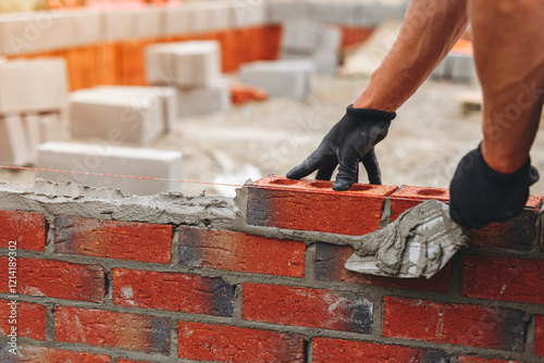 Close-up of Skilled worker lays bricks at construction site 