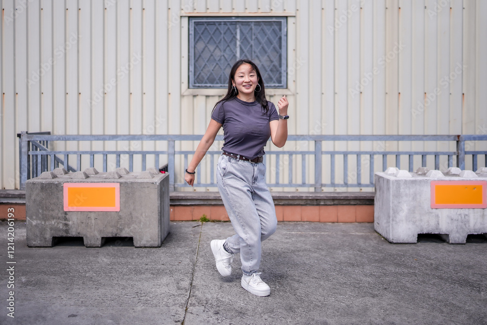 Happy asian girl dancing free style in an urban space Happy asian girl dancing free style in an urban space
