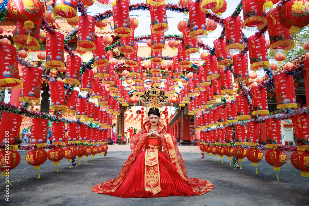 Naklejka premium portrait of young asian woman wearing a traditional Chinese red dress sitting is posing.