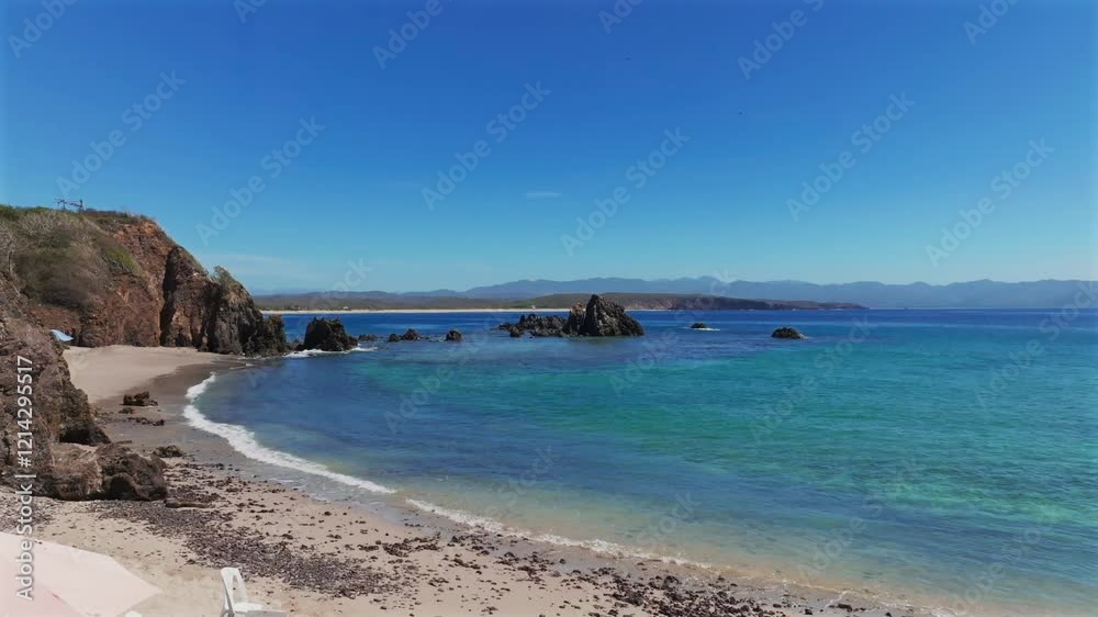 La Morita Beach during low tide with turquoise crystal-clear waters, white sand and rocky shores. Snorkeling haven with coral reefs, Tenacatita, Mexico