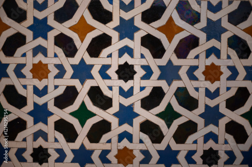 Ornamental colourful geometric medieval ceramic tiles of walls in old castle, Sevilla or Granada, Andalusia, Spain. Arabic ornament background wallpaper photo