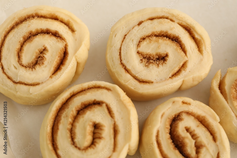 Many uncooked cinnamon rolls in baking dish, closeup Many uncooked cinnamon rolls in baking dish, closeup