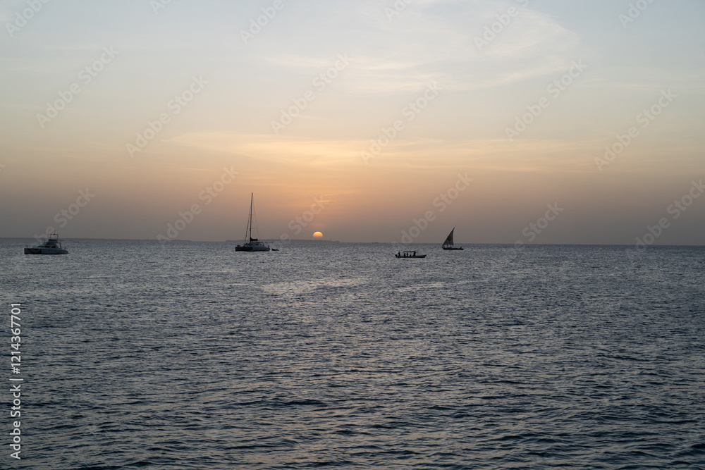 Boats and Sun Dipping Below the Horizon in Zanzibar Boats and Sun Dipping Below the Horizon in Zanzibar
