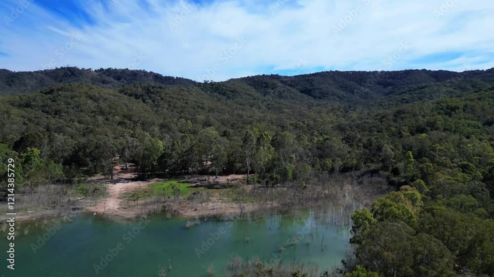 A stunning aerial view of Lake Eildon, Australia, captured by a drone. The vibrant blue water, lush green islands, and surrounding hills create a serene and picturesque landscape under a clear sky A stunning aerial view of Lake Eildon, Australia, captured by a drone. The vibrant blue water, lush green islands, and surrounding hills create a serene and picturesque landscape under a clear sky