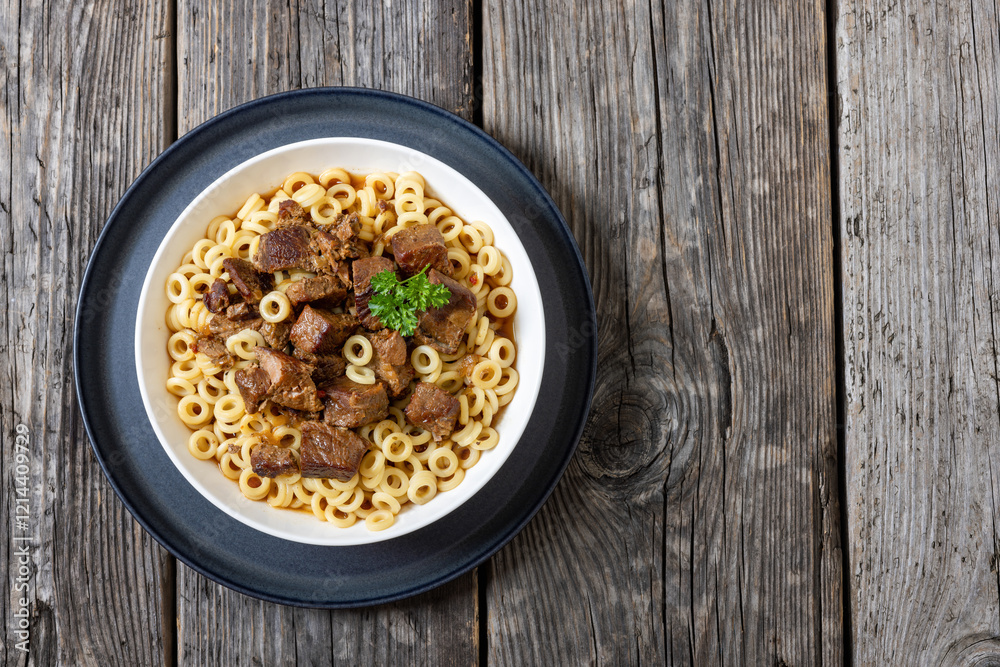 pasta rings topped with braised meat in bowl pasta rings topped with braised meat in bowl