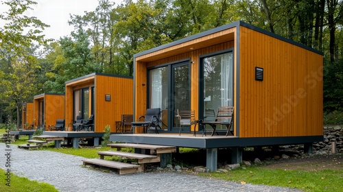 Modern Cabins in a Forest Setting: A row of sleek, modern cabins with wooden siding and large windows nestle amidst a verdant forest, offering a tranquil and secluded escape.  